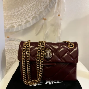 Vinröd quiltad axelväska från Kurt Geiger - Intresse koll på min snygga vinröda axelväska från Kurt Geiger med guldfärgade kedjedetaljer. Köpt i london (dustbag tillkommer) nypris ca 3000 