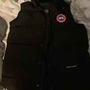 Svart dunväst från Canada Goose - Skriv bud om priset är för hökt. Västen e bra skick riktig fin bra för en kall dag!.