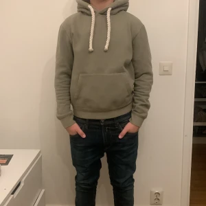 Syna world - Snygg grön hoodie från syna world med stort tryck på huvan och rejäla snören. Perfekt för en avslappnad stil.