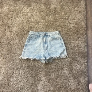 Ljusa jeansshorts med slitningar  - Snygga ljusa jeansshorts med lite slitningar längsned. Aldrig använda och är i helt nytt skick. Säljer dom för att dom var för stora och då inte kommer till användning 