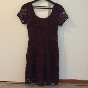 Vinröd spetsklänning från Hollister - Snygg vinröd klänning från Hollister i spets med korta ärmar och rund hals. 