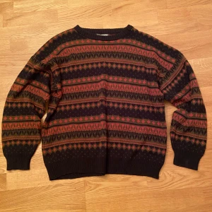 Grandpasweater/stickad tröja - Säljer en mysig stickad tröja med ett detaljerat mönster i svart,orange och grön. Köpt på Beyond retro för ca 600kr. Använd 2 ggr och i perfekt skick.