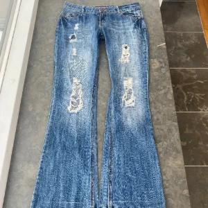 Blå bootcut jeans med slitningar - Säljer mina jättefina lågmidjade jeans som jag köpte här på plick!🩷 de är i jättefint skick! Midjemåttet är 41cm och innerbenslängden är 83cm. 