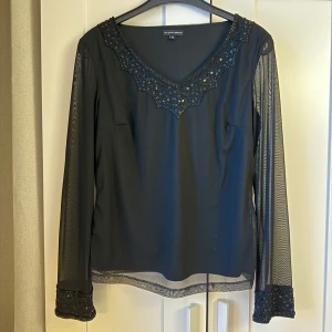 Svart festtopp - Superfin svart tröja i storlek S, ärmarna är i mesh. Använd fåtal gånger och det är inga defekter. 