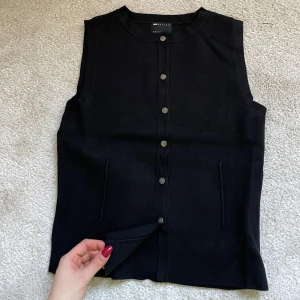 Svart väst från asos S - Snygg svart väst från Massimo Dutti med knappar framtill. Perfekt för en stilren look. Västen har en klassisk design med rund hals och två fickor.