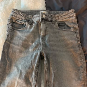 Grå jeans - Snygga grå jeans med klassisk femficksdesign och knappgylf. Perfekta för en avslappnad stil. De har en diskret tvättad look som ger dem en cool touch.