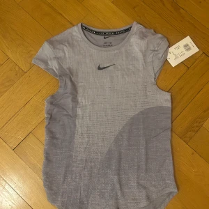 Lila träningstopp från Nike!!! - Säljer en snygg lila träningstopp från Nike! Toppen har en rund hals och korta ärmar med en diskret Nike-logga på bröstet. Ny med lapp kvar! Aldrig använd! Pris kan diskuteras💕Orginalpriset är 900!