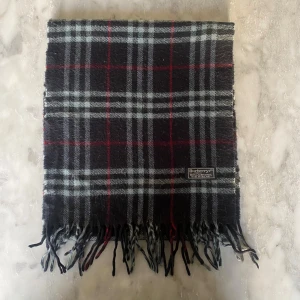 Svart burberry halsduk  - Skick: 8/10. Halsduken är i bra skick och har inga defekter. Mått: 144cm x 31cm 