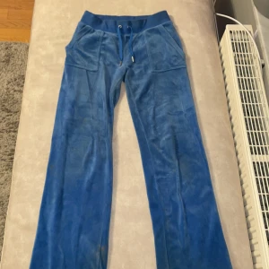 Blå mjukisbyxor med snörning - Snygga juicy mjukisbyxor i mjukt material med snörning i midjan. Byxorna har fickor fram och bak, samt en bekväm passform. Ni kan fråga om ni vill ha bild när man har på sig dem 