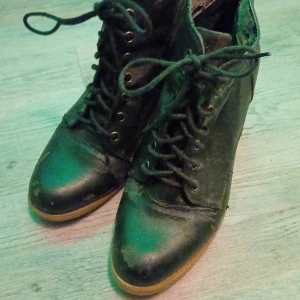 Svarta boots med snörning - Svarta boots i skinn med snörning och rund tå. Skorna har en robust design med slitna detaljer som ger en vintagekänsla. Perfekta för en edgy look.