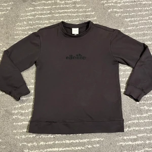 Ellesse black label crewneck - En ellesse crewneck med svart broderad logga. Den är i storlek 10 och sitter ungefär som en tröja i storlek S. Den har en mindre skada på sömmen på framsidan, men den syns inte så mycket. Pris går att diskuteras, bara att höra av sig ifall man har några frågor om mått, mer detaljerade bilder eller liknande.
