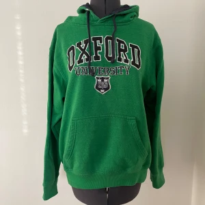 Grön hoodie med Oxford University-tryck - Grön hoodie med Oxford University-tryck på bröstet. 