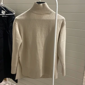 Beige polotröja - Snygg och stilren beige polotröja med ribbade detaljer vid kragen 💕från H&M aldrig använd helt ny. Säljer då den är förstor. Storlek s men skulle säga är mer en m 
