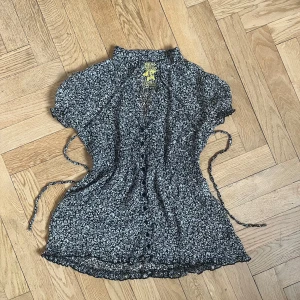 Söt blus! - Supersöt blommig blus från Miss Poem! Väldigt luftig, perfekt till sommarn! På framsidan har den knappar och snörren att knyta vid halsen.