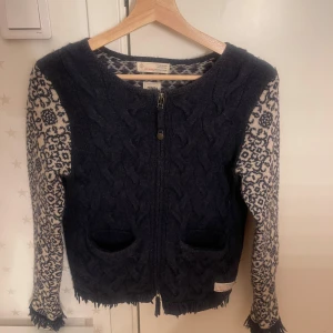 Mönstrad kofta från Odd Molly - Säljer en unik kofta från Odd Molly med ett vackert mönster i marinblått och vitt. Koftan har en dragkedja framtill och två fickor. Perfekt för att hålla sig varm och stilren under kyliga dagar. Storlek 1 och det motsvarar ungefär xs-m🥰