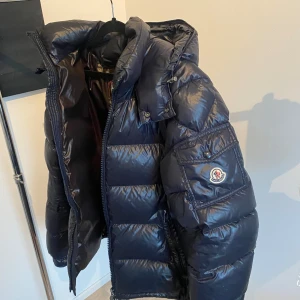 Mörkblå Moncler Maya  - Säljer min jacka i stl 3 vilket motsvarar L men sitter lite mindre. Jackan har en mindre skada inne i jackan