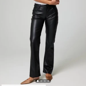 Svarta skinnbyxor - Snygga svarta skinnbyxor med medel midja och bootcut.