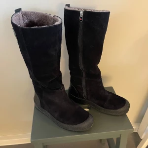 Svarta vinterstövlar från Canada Snow - Säljer ett par svarta vinterstövlar från Canada Snow. Stövlarna är i mocka med dragkedja på sidan och har en varm, pälsfodrad insida. Perfekta för kalla vinterdagar.