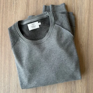 Emilio grå ullmix tröja, storlek M - En grå tunn stickad tröja med två olika strukturer i fint skick, behöver bara eventuellt köras med noppborttagare nere till höger.   40% akryl, 30% ull, 30% bomull.   Hör av dig vid funderingar.