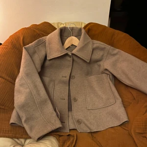 Beige kappa från kappahl - Snygg beige kappa från kappahl. Orginalpris- 900kr Jackan har långa ärmar och stora fickor framtill. Perfekt för höst och vår.