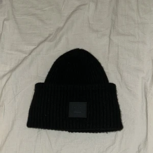 Svart mössa från Acne Studios - Tja! Säljer nu min acnes studios mössa för den är för liten, den är helt ny så skicket är 10/10. Tillverkad av 100% ull för extra värme och komfort. Perfekt för kyliga dagar.