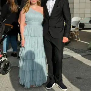 Elegant ljusblå långklänning med oneshoulder-design och volangdetaljer. Perfekt som balklänning till studenten! Endast använd 1 gång, Köpt härifrån Plick för 900kr men den var helt ny och oanvänd då, från ASOS. Klänningen är i M men Petite så passade mig jättebra som är 157cm och hade klackar som var 6cm. Undrar du något annat, bara att skicka ett meddelande😊