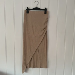 Snygg tajt kjol med slits - New Yorker ❤️ - Jättesnygg beige tajt kjol med slits. Lite längre modell! Storlek 34. Lika snygg till fest som vardags. Använd endast 1 gång, jättefint skick!