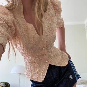Beige spetsblus med knappar - 💕Säljer en superfin ljusrosa spetsblus med knappar framtill. Den har en vacker blommig spetsdesign och trekvartsärmar. Perfekt för både vardag och festliga tillfällen! OBS endast avhämtning på Södermalm. 