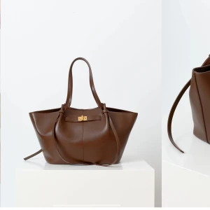 Gina Tricot stor väska - Stor väska i läderimitation med dubbla handtag. Väskan är brun och har guldfärgat spänne. Den har magnetknäppning och innerfack. Slutsåld på gina, den är köpt för nån vecka sen men har bara använt den två gånger så verkligen som ny!