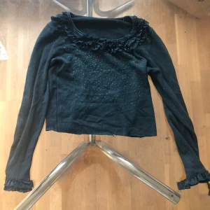 En svart tröja - En svart tröja med mörkgröna krystaler