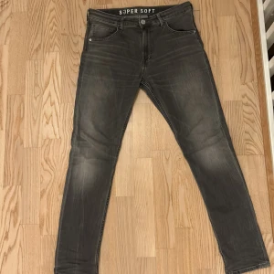 Grå jeansbyxor  - Snygga grå jeansbyxor från H&M med en slim passform. Byxorna har en klassisk femficksdesign och är tillverkade i ett mjukt material för extra komfort. Perfekta för en stilren look.