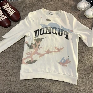 Vit sweatshirt från Dondup - Säljer en sweatshirt från Dondup som är slutsåld överallt. Tröjan har långa ärmar och en rund halsringning. tröjan är i nytt skick och är endast använd en gång nypris ligger runt 2000 medans jag säljer tröjan för 1299. Har du några frågor så besvarar jag dem gärna. jag gör paketpris vid köp flera varor och Jag tar gärna emot byten.