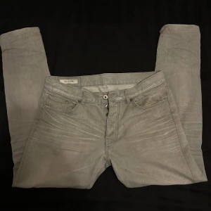 Grå jeansbyxor från VALENTINO - Snygga grå jeansbyxor från Valentino Garavani med en klassisk femficksdesign. Byxorna har en rak/slim passform och är tillverkade i ett bekvämt material. Perfekta för en stilren look. Storleken är w29 men passar även w30.