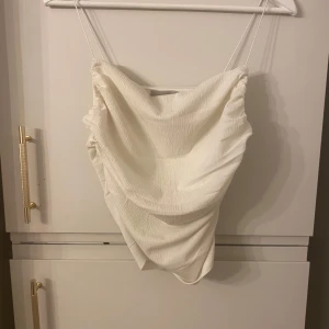 Vit ribbad linnetopp - Säljer en vit ribbad linnetopp med tunna axelband. Perfekt för varma dagar och kan enkelt matchas med olika outfits. Toppen har en enkel och elegant design.  Har andvänts endast 2 gånger 💋