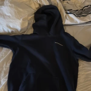 Mörkblå hoodie från Peak Performance - Säljer en stilren mörkblå hoodie från Peak Performance. Den har en klassisk design med en stor huva och en praktisk magficka. Perfekt för en avslappnad look.
