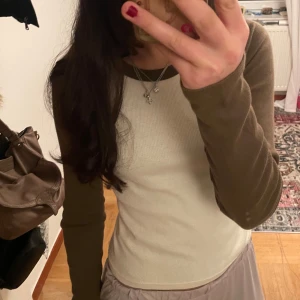 Brun och vit långärmad topp från Brandy Melville - Säljer en snygg långärmad topp från Brandy Melville i brun och vit färg. Den är tillverkad i bomull och har en bekväm passform. Använd 2 gånger.