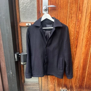 Overshirt från A days march i 100%ull. - Snygg mörkblå  jacka från A Day's March i storlek small. Jackan har en klassisk design med knappar framtill och långa ärmar. Perfekt för en stilren look. Hör av er vid frågor!👍