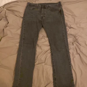 Grå Levis 501 jeans - Säljer ett par grå Levis 501 jeans i straight fit. Var i storlek W31 L32 men kortats ner till W31 L30