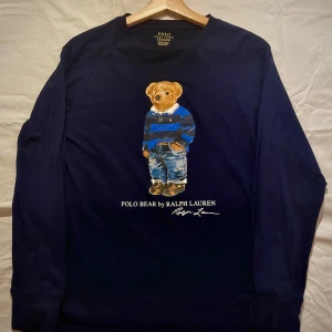 Ralph Lauren Polo Bear Longsleeve - Säljer en snygg Longsleeve fårn Ralph Lauren med den ikonsika polo björnen. Tröjan är i mycket fint skick då den använts sparsamt. Stl 14-16 vilket motsvarar stl S. Nypriss: 1095kr  Mitt pris: 499.  Tveka inte på att ställa frågor i dm!💯