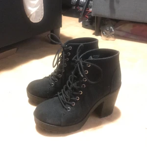 Svarta boots med klack - Snygga svarta boots med hög klack och snörning. Perfekta för att ge lite extra höjd och stil till din outfit. De har en robust design med en bekväm passform.