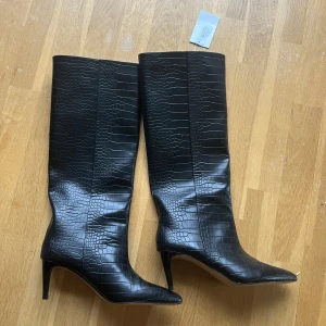 Svarta stövlar med krokodilmönster från H&M - FLYTTAR UTOMLANDS 1 FEBRUARI  Supersnygga svarta stövlar i krokodilskinnsmönster med spetsig tå. Klack 6,5 cm. Aldrig använda endast provade