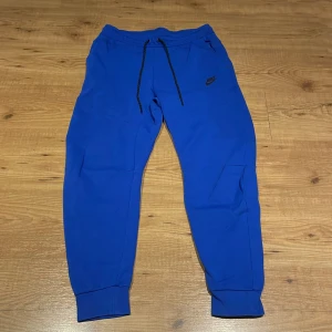 Blå Nike tech fleece byxor - Blåa tech fleece byxor i bra skick. inga skador eller slitningar säljs då jag inte använder de längre. pris är ej hugget i sten