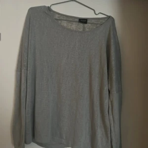 Grå tröja från Vila - Säljer en enkel och stilren grå tröja från Vila. Tröjan har en rund halsringning och långa ärmar, perfekt för en avslappnad look. Passar bra till både jeans och kjol.