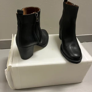 Oanvända Svarta boots med dragkedja - Oanvända Snygga svarta boots i skinn med dragkedja på sidan och en stabil klack. Perfekta för både vardag och festliga tillfällen. Enkla att matcha med olika outfits.