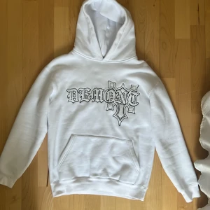 Demont Hoodie - Demont’s OG Hoodie i vit med tryck på bröstet i storlek small.  Den är i superbra skick, inga fläckar eller skador osv men syns ändå lite att den använts därför sänker jag priset en del.  Säljer då den aldrig kommer till användning längre.