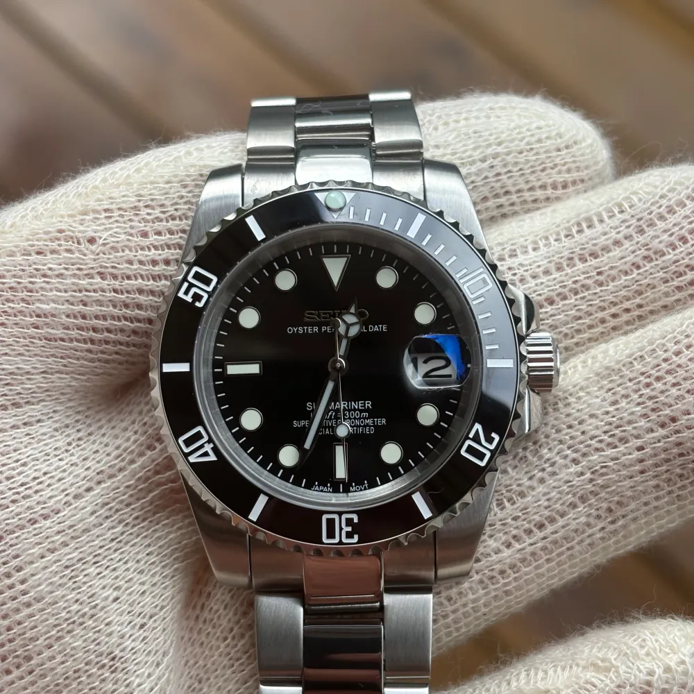 Tja! Har en Seiko Submariner Black Mod som jag säljer! Använd en gång på armen men är i nyskick såklart. Om klockan: NH35 automatisk rörelse. 904L Stainless Steel. C3 Lume (lyser i mörket). Blänkande Oyster armband. Verktyg till länkar ingår!. Accessoarer.