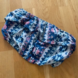 Mönstrad bikiniunderdel från Hollister - Säljer en superfin tubtopp från Hollister i storlek S. Den har ett coolt mönster i blått, rosa och vitt som verkligen sticker ut. Perfekt för sommaren och strandhäng! Materialet känns mjukt och bekvämt, och passformen är normal. Ett måste för din garderob!