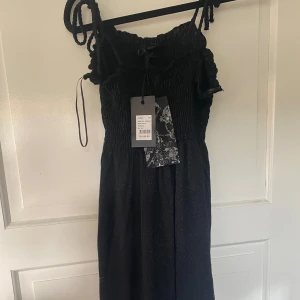 Svart glittrig klänning från Cubus - Säljer en superfin svart glittrig klänning från Cubus i storlek XS🥰 helt oanvänd med prislapp kvar!
