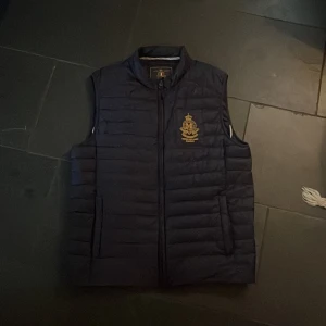Morris väst storlek M - Morris väst skick 9/10 använd rätt så mycket men har tagit väl hand om. Inga defekter eller liknande. Färg marinblå storlek M, nypris 1800kr