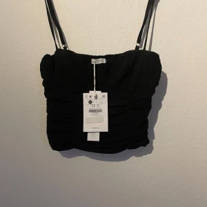 Topp - En fin festtopp jag köpte för närmare 2 år sedan. Den är aldrig använd då den var för liten för mig. Det är dragkedja på sidan men lite stretch. Har råkat förstöra ens bygeln så den sticker ut på ena sidan men ser ut som det går att lösa lätt!